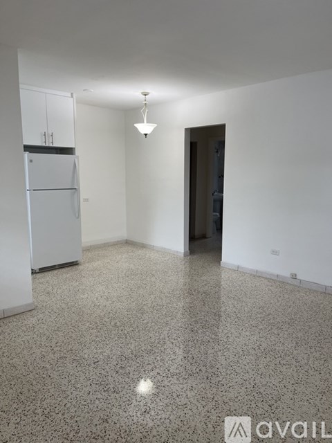 A kitchen with a fridge and a dining table.