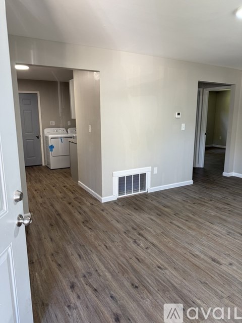 A room with a white door and a wood floor.
