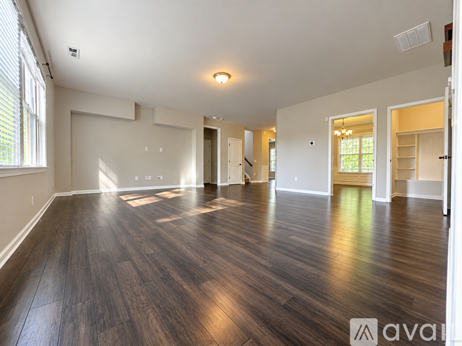 A spacious room with wooden floors and white walls.