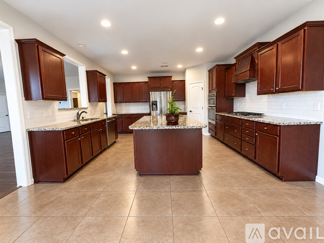 A kitchen with brown cabinets and a marble island.