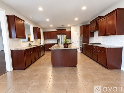 A kitchen with brown cabinets and a marble island.