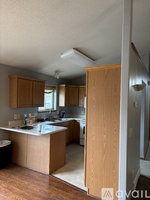 A kitchen with wooden cabinets and a white countertop.