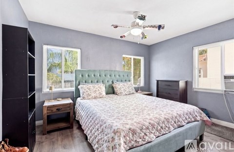 A bedroom with a bed, nightstand, and a ceiling fan.