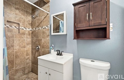 A bathroom with a toilet, sink, and shower.