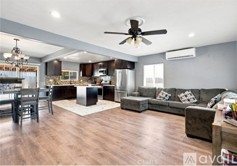A spacious living room with a kitchen in the background.