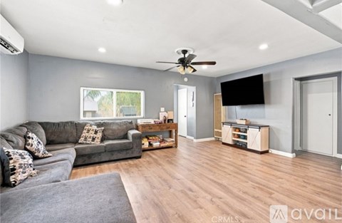 A living room with a grey couch and a wooden floor.