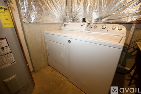 A white stove is in a room with aluminum foil on the walls.