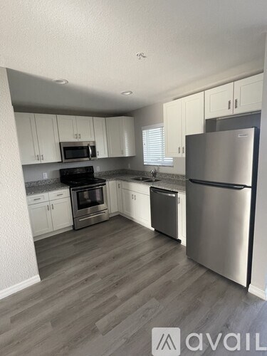 A kitchen with a refrigerator, oven, and microwave.