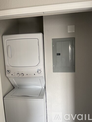 A white washing machine sits in a small laundry room.