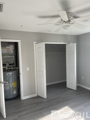 A room with a ceiling fan and a doorway leading to another room.