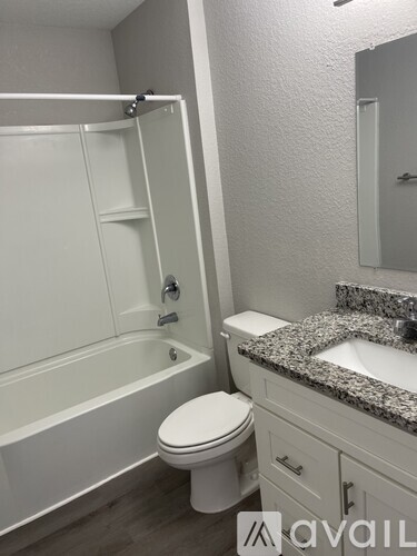 A bathroom with a white toilet, sink, and bathtub.