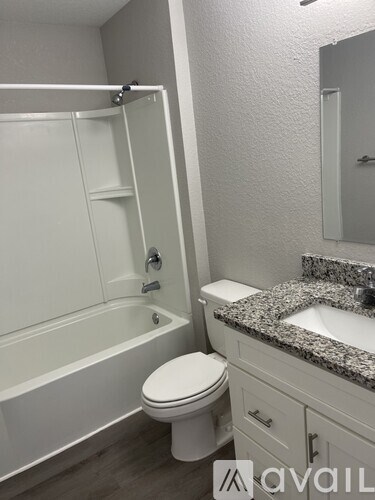 A bathroom with a white toilet, sink, and bathtub.
