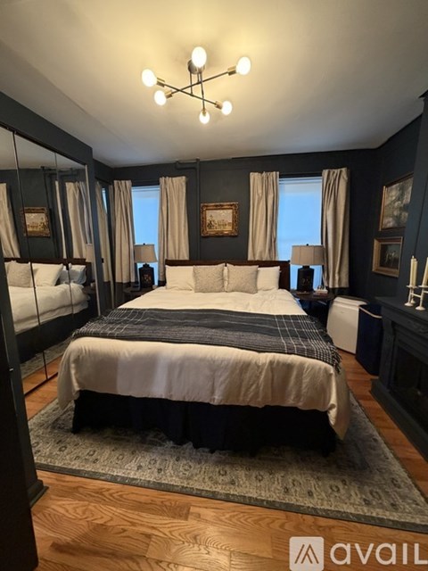 A bedroom with a large bed and a chandelier.