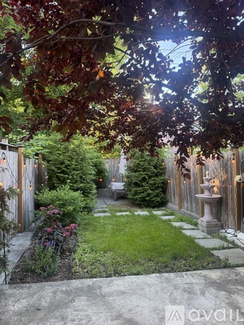 A garden with a fountain and a bench.