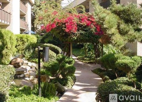 A garden pathway with a flowering archway.