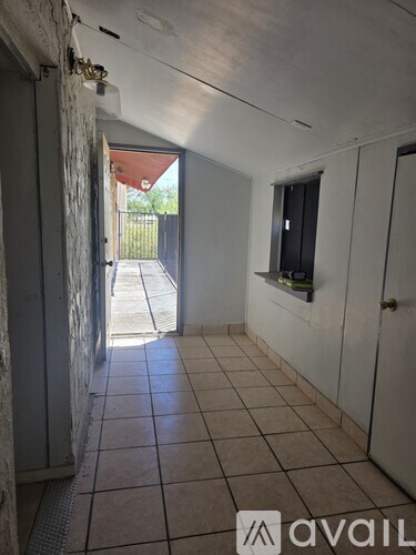 A hallway with tiled floors and white walls.