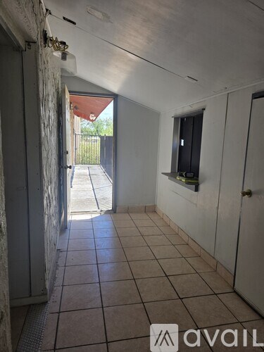 A hallway with tiled floors and white walls.