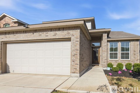 A house with a white garage door and a brown brick exterior.