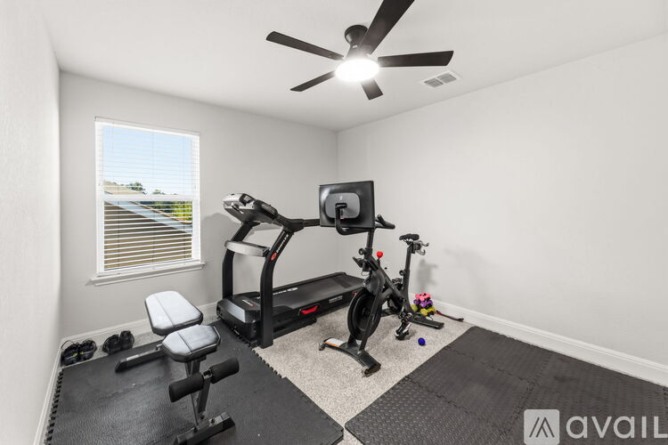 A home gym with a treadmill, stationary bike, and a bench.
