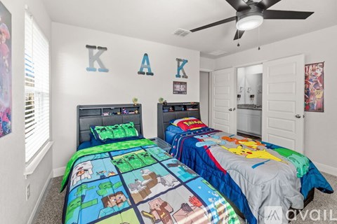 A bedroom with two beds and a ceiling fan.