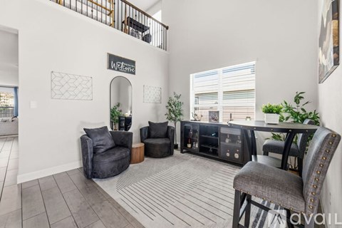 A living room with a grey sofa and a wooden floor.