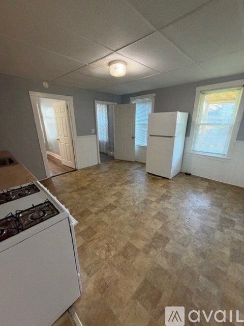 A kitchen with a gas stove and a tiled floor.