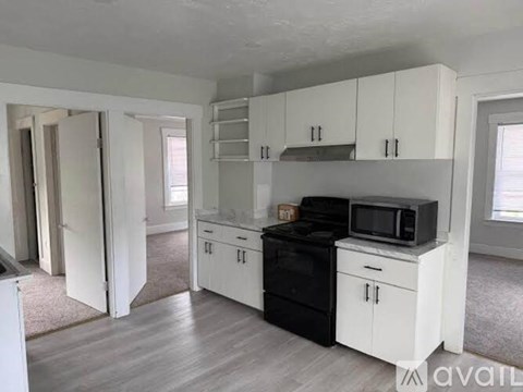 A kitchen with white cabinets and appliances.