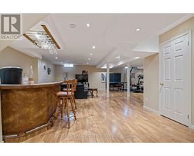 A well-lit, spacious living room with a bar area and a dining area in the background.