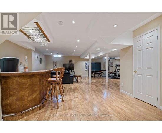 A well-lit, spacious living room with a bar area and a dining area in the background.