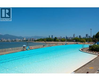 A large swimming pool with a view of the city in the background.