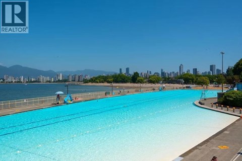 A large swimming pool with a view of the city in the background.