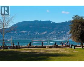 A park with people walking and a mountain in the background.