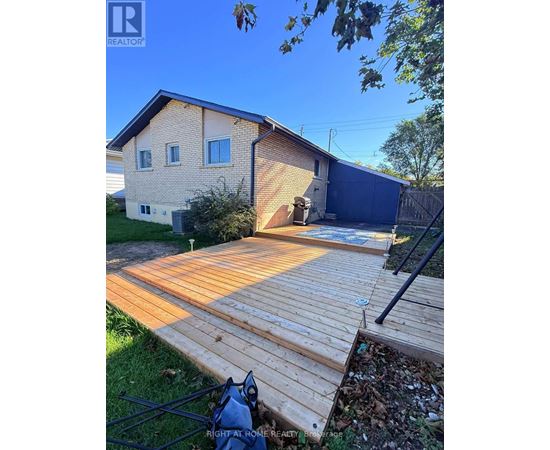 A wooden deck leads to a garage in a residential backyard.
