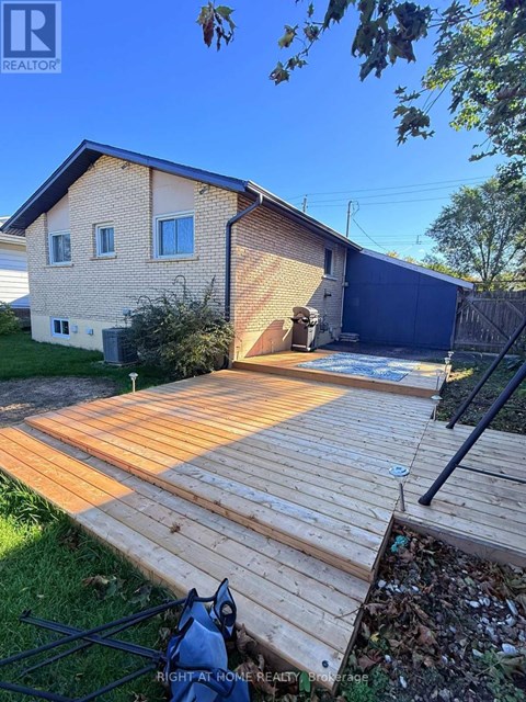 A wooden deck leads to a garage in a residential backyard.