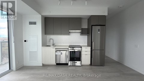 A modern kitchen with stainless steel appliances and white cabinetry.