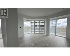 A spacious room with a view of the cityscape through large windows.