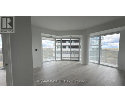 A spacious room with a view of the cityscape through large windows.