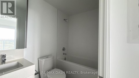 A white bathroom with a toilet, sink and bathtub.