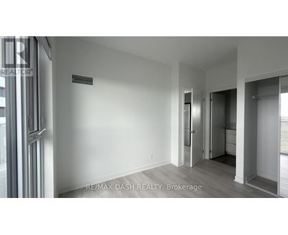 A room with a door and a window with a sign RE/MAX DASH REALTY, Brokerage.