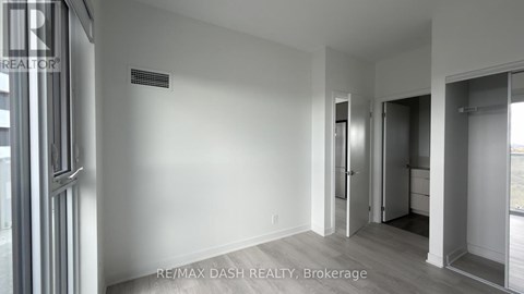A room with a door and a window with a sign RE/MAX DASH REALTY, Brokerage.