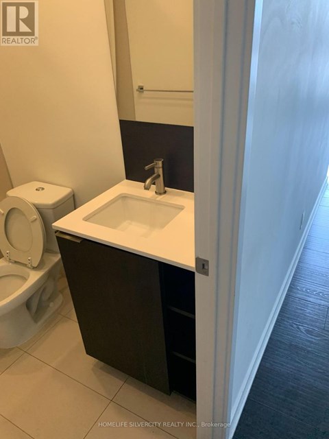 A white sink in a black cabinet in a bathroom.