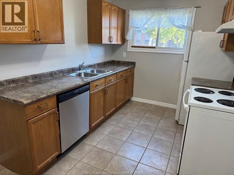 A kitchen with wooden cabinets and a granite countertop.
