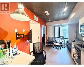 A modern office space with orange walls and a concrete ceiling.