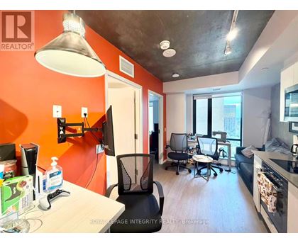 A modern office space with orange walls and a concrete ceiling.
