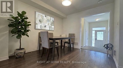 A dining room with a table and chairs.