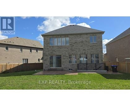 A house with a stone facade and a black gate in front.