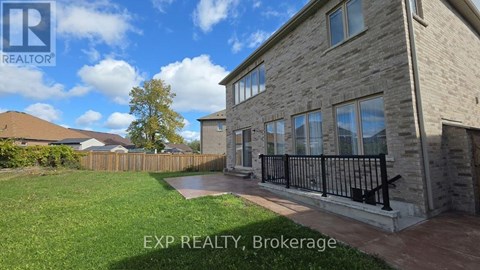 A house with a lawn and a fence in front of it.