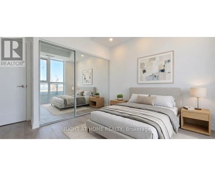 A bedroom with a large bed, a nightstand, and a painting on the wall.