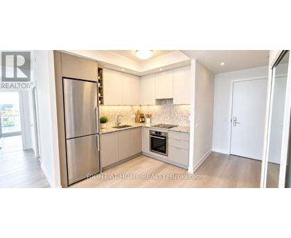 A kitchen with a refrigerator, sink, and countertop.