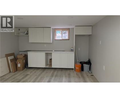 A room with a window, cabinets, and a broom.